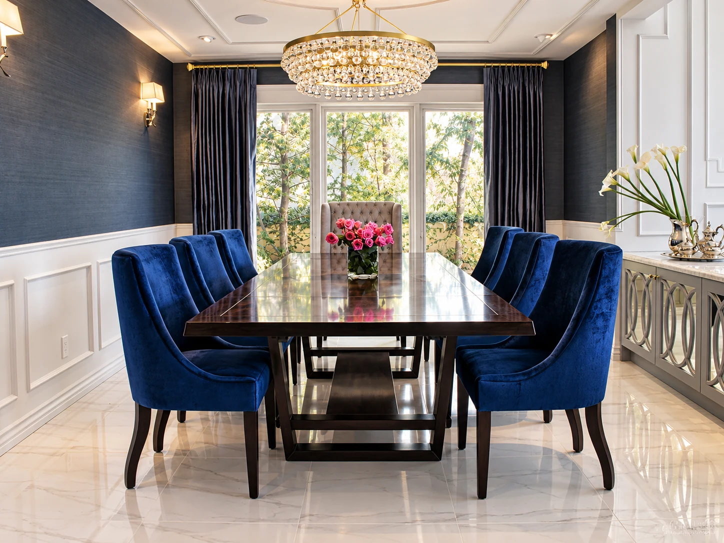 Dining room with rich blue velvet chairs and a glass chandelier
